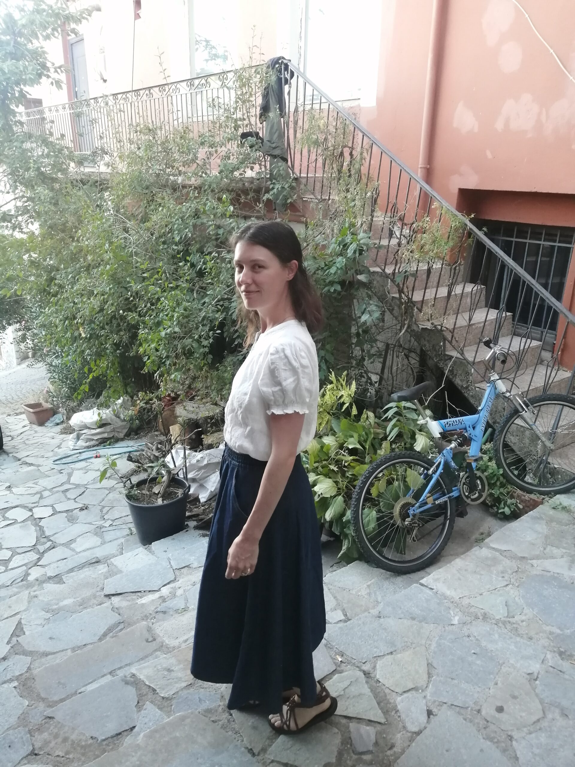 Claire Erasmus stands in a cobblestone street, smiling.